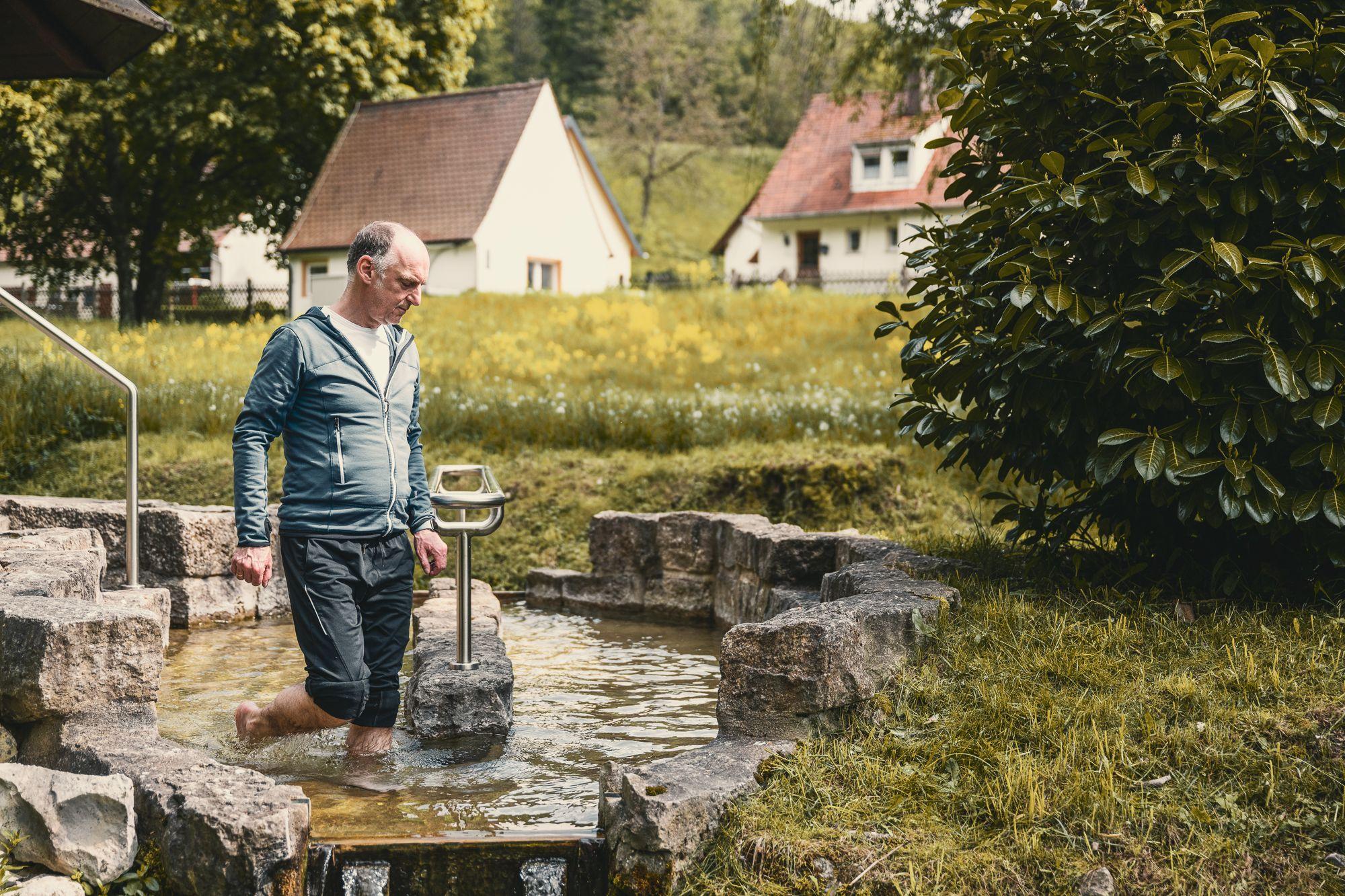 Patient beim Wassertreten im Garten.