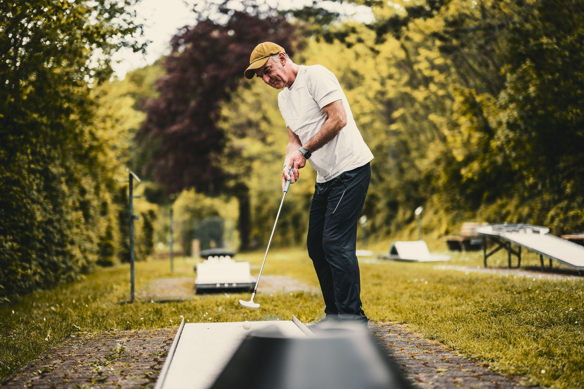 Ein Mann beim Minigolf-spielen. 