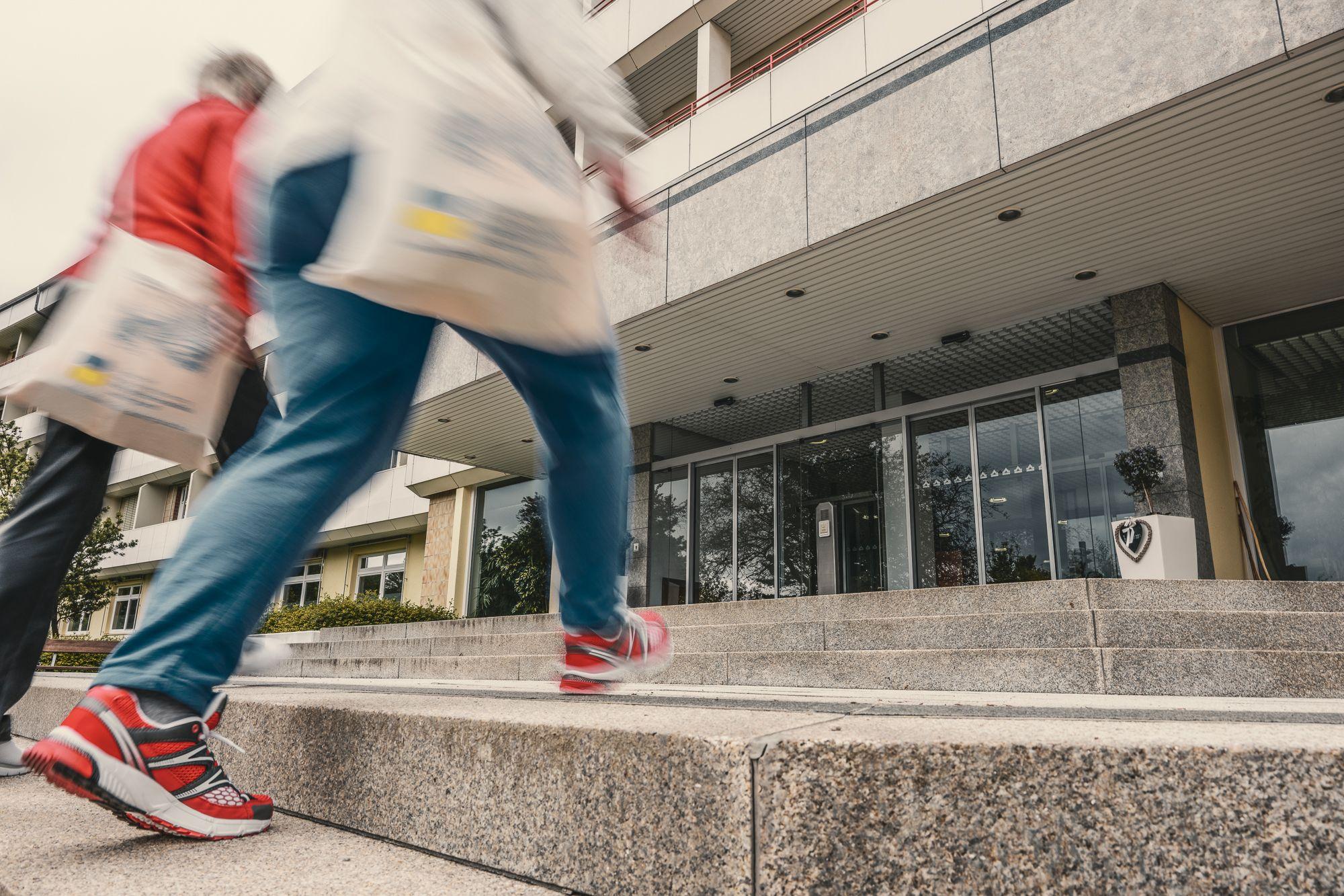 Außenansicht der Rehaklinik Lautergrund. 2 Frauen gehen die Treppe zum Eingang hoch. 