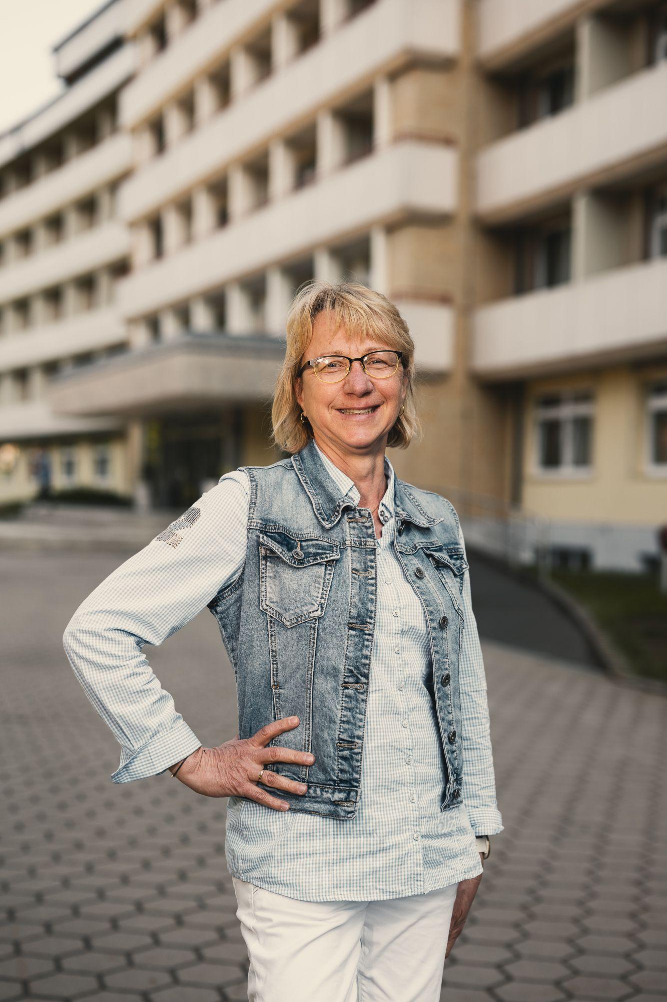 Eine Patientin steht vor der Klink und schaut in die Kamera.