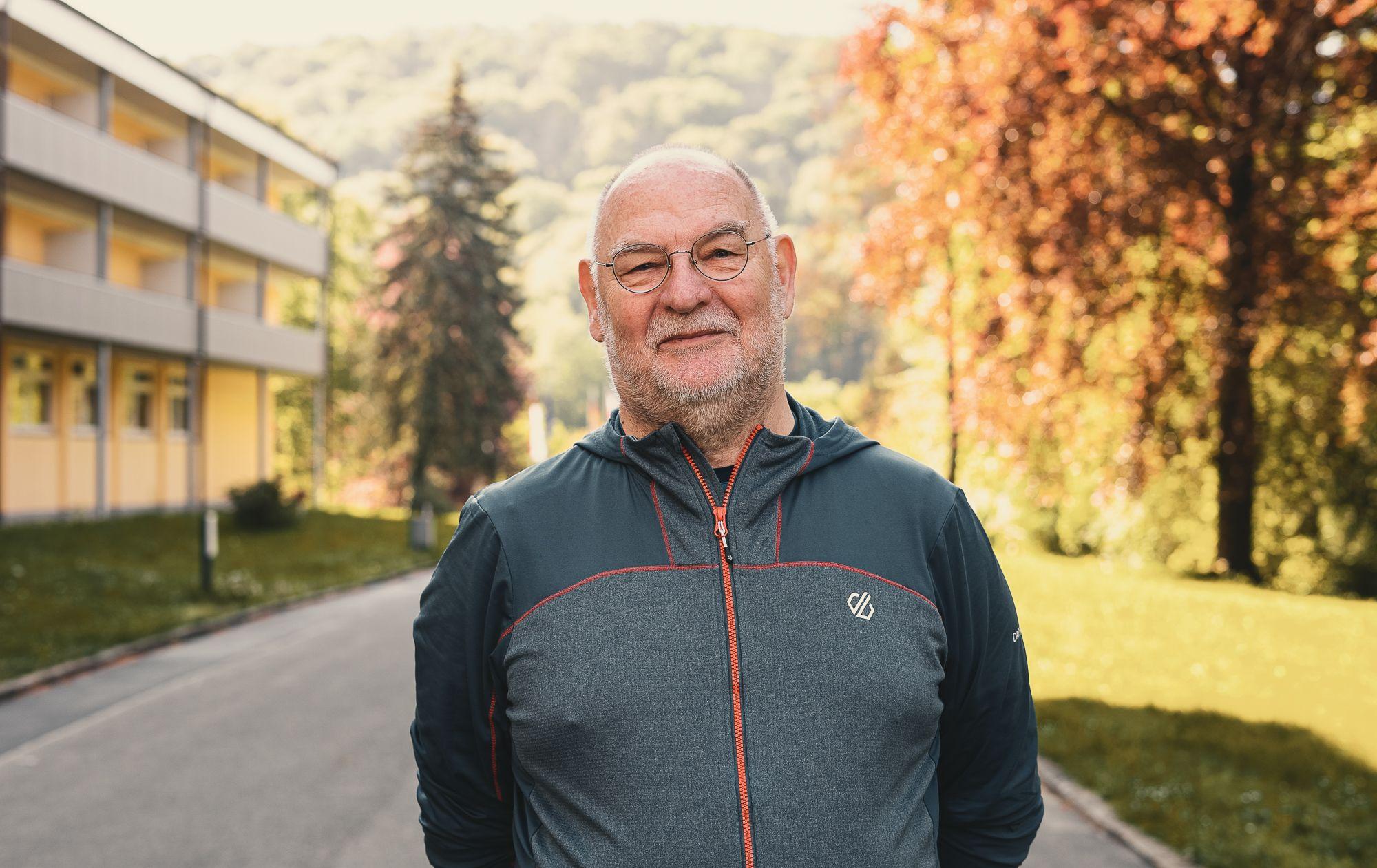 Ein Patient steht vor der Klink und schaut in die Kamera.